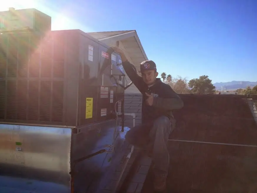 HVAC technician performing AC Tune-Up on a rooftop unit in Stuttgart